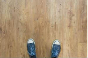 Flooring showing man’s feet with pair of sneaker