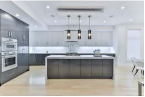 Open kitchen concept with long island, grey and white cabinet, and recessed ceiling light