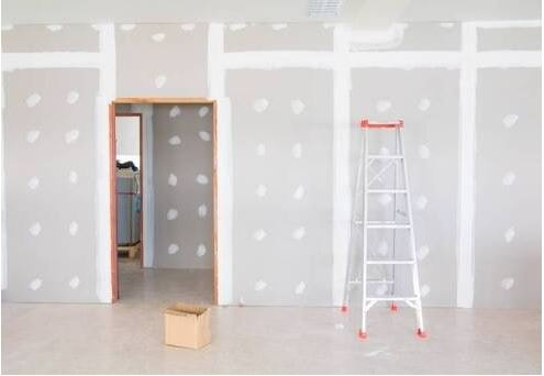 Unfinished drywall with ladder close to wall