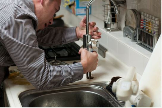 Plumber installing faucet