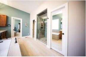 Large bathroom with open shower with glass door